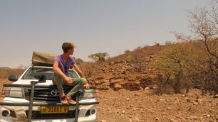 Paul Stoll beobachtet von der Motorhaube aus eine Giraffe