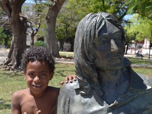 Kubanisches Kind neben einer Statue