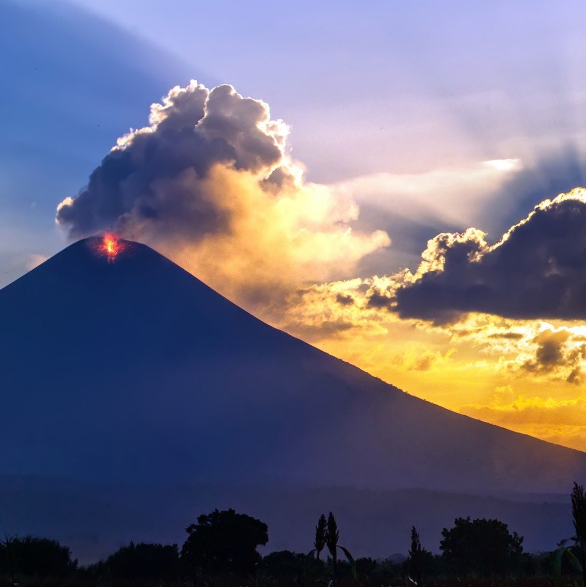 Sonne geht dramatisch hinter einem Vulkan unter