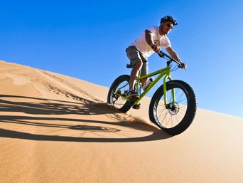Mann auf Fatbike-Tour in der Wüste