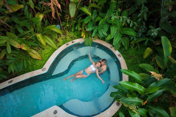 Costa Rica Reisen: Zwei Menschen im Jacuzzi umgeben von tropischen Pflanzen