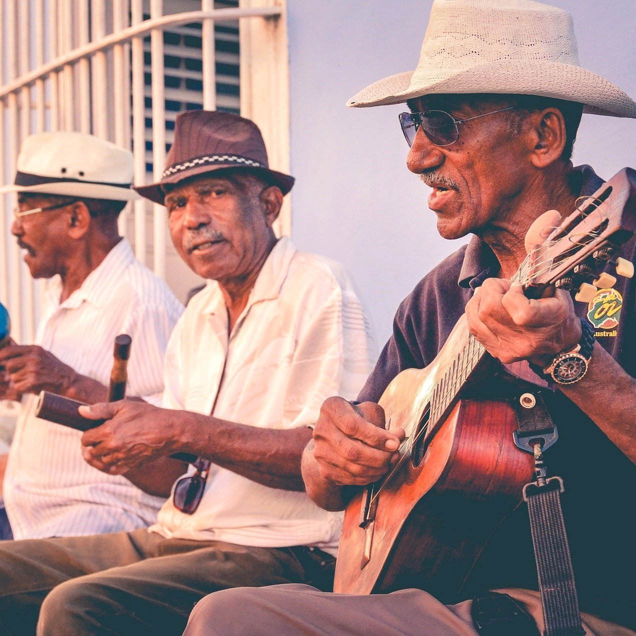 Drei Musiker auf einer Bank in Kuba