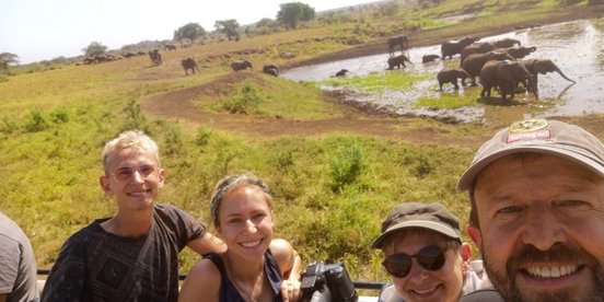 Familie in Uganda vor einer Elefantenherde