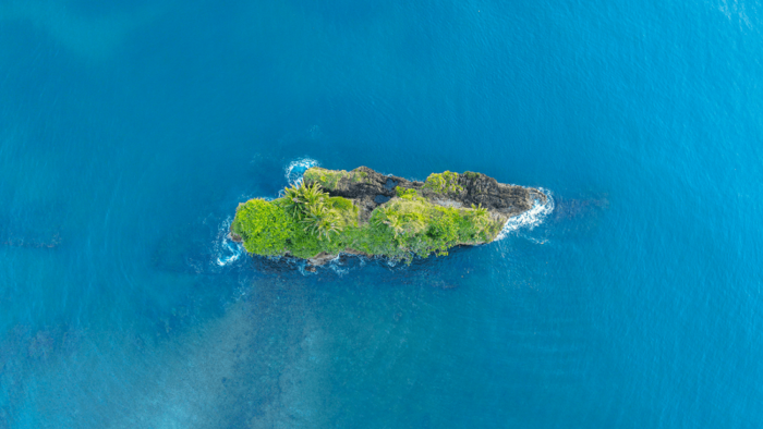 Kleine grüne Insel im blauen Meer