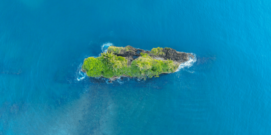 Kleine grüne Insel im blauen Meer