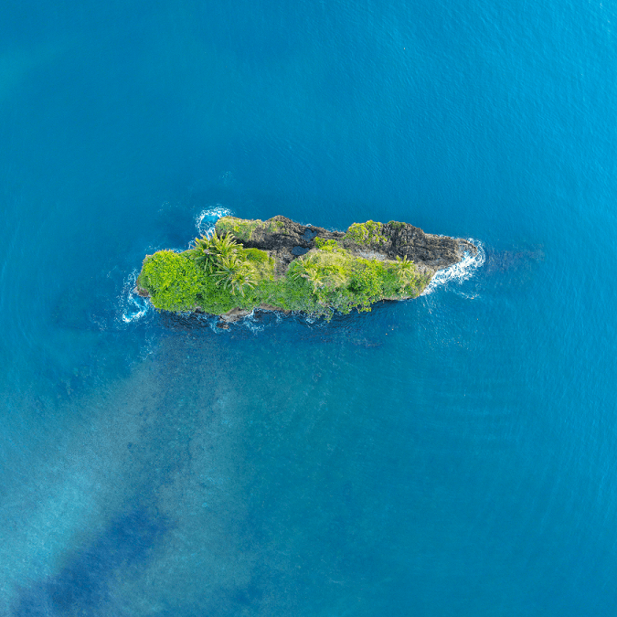 Kleine grüne Insel im blauen Meer