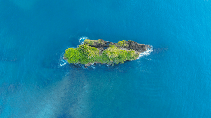 Kleine grüne Insel im blauen Meer