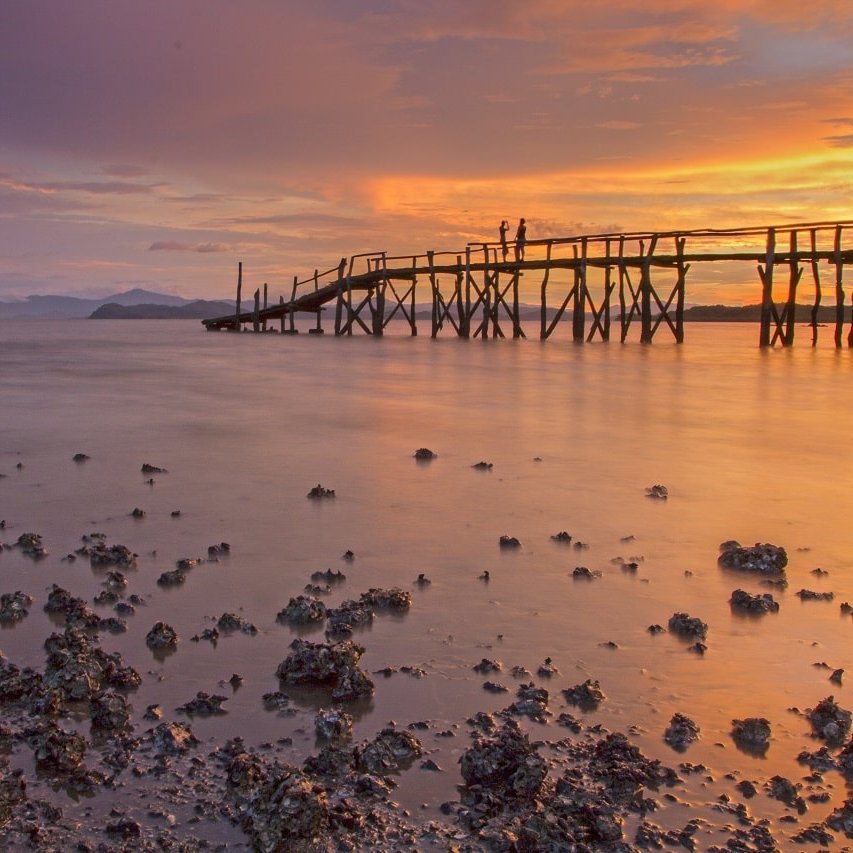 Ein Steg im Meer bei Sonnenuntergang