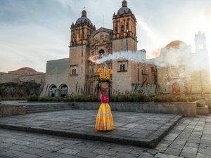 Bei mystischer Stimmung steht eine Frau vor einer alten Kirch in Mexiko