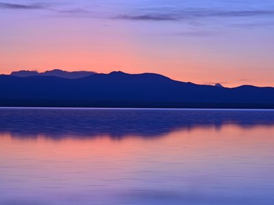 Sonnenuntergang hinter Bergen an einem See in Bolivien