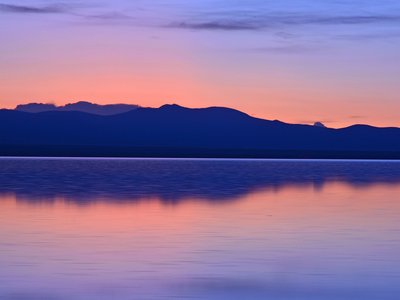 Sonnenuntergang hinter Bergen an einem See in Bolivien